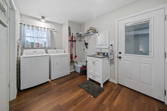 clothes washing area featuring dark hardwood / wood-style flooring, sink, and washer and clothes dryer