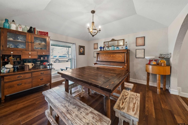 dining area featuring an inviting chandelier, a tray ceiling, dark hardwood / wood-style floors, and vaulted ceiling