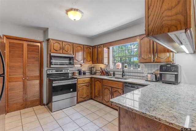 1304 Azalea Dr, Sulphur Springs, TX 75482 - kitchen with appliances with stainless steel finishes, decorative backsplash, brown cabinets, and light tile patterned floors