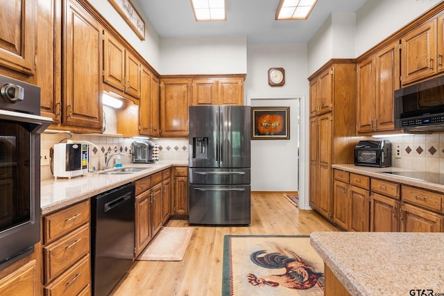 19132 Falls Creek Dr, Flint, TX 75762 - kitchen with brown cabinets, decorative backsplash, a sink, and black appliances
