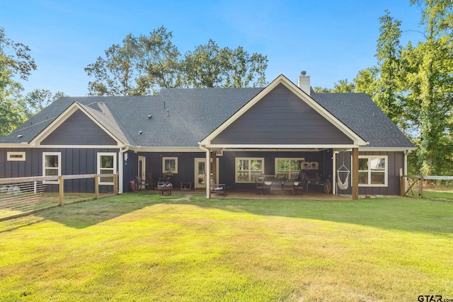 rear view of property with a patio and a lawn