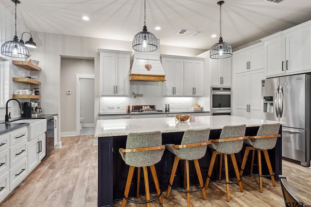 kitchen with white cabinetry, stainless steel appliances, and hanging light fixtures