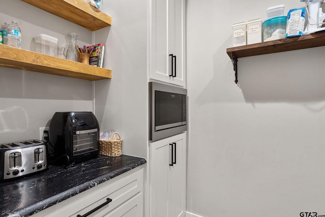 kitchen with white cabinetry and stainless steel microwave