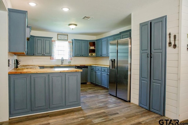 kitchen with visible vents, stainless steel fridge with ice dispenser, dishwashing machine, a peninsula, and a sink