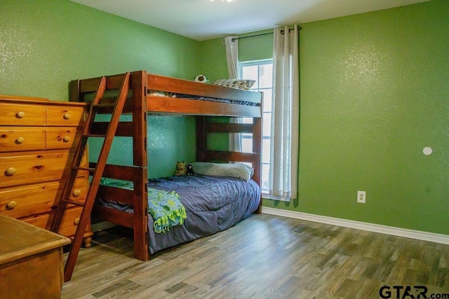 bedroom with baseboards and wood finished floors