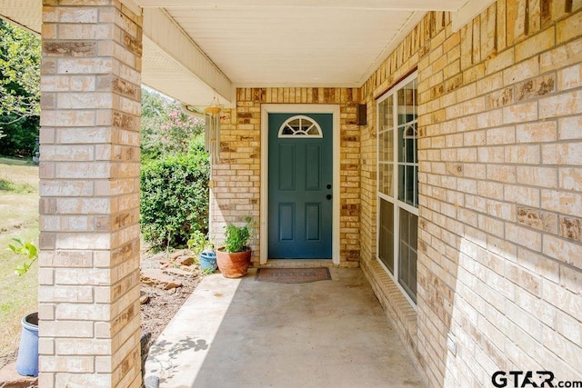 view of exterior entry with brick siding