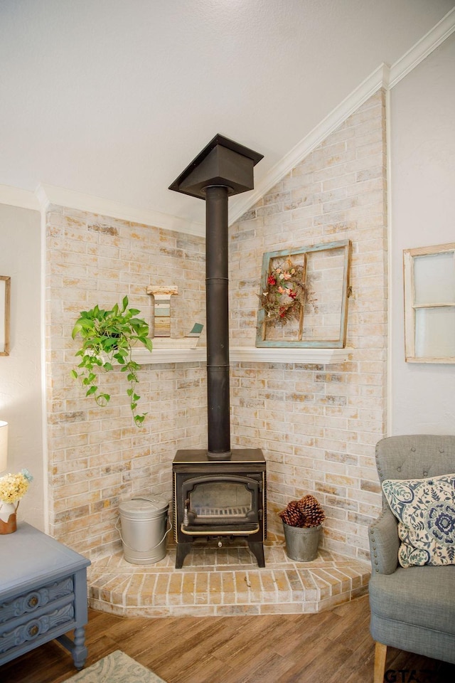 details with ornamental molding, a wood stove, and wood finished floors