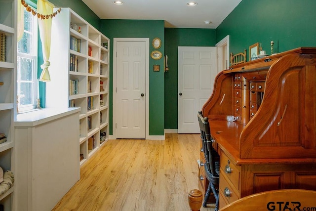 living area with baseboards, recessed lighting, light wood-type flooring, and a healthy amount of sunlight