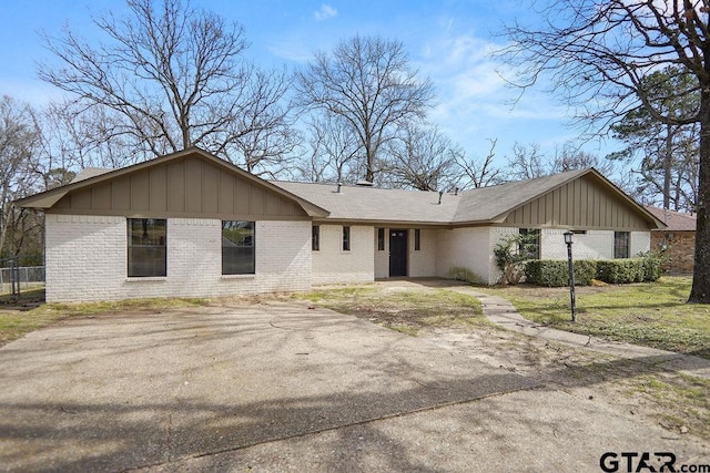 single story home with brick siding and driveway