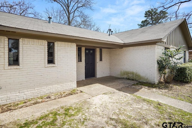 doorway to property featuring brick siding