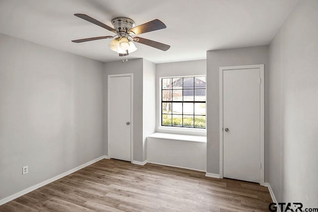 unfurnished room with ceiling fan, baseboards, and wood finished floors