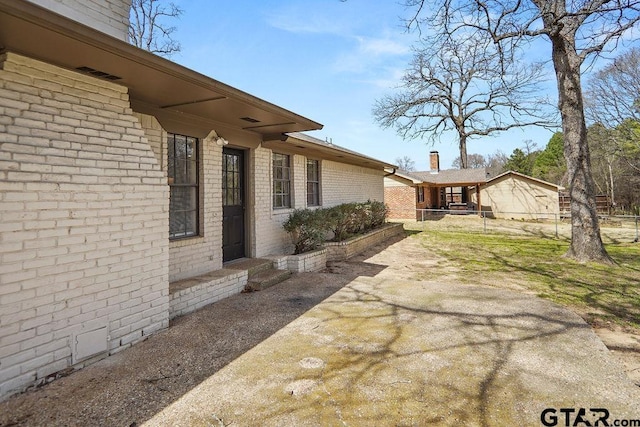 exterior space featuring brick siding and fence