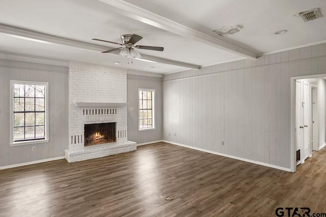 unfurnished living room with beamed ceiling, baseboards, visible vents, and wood finished floors