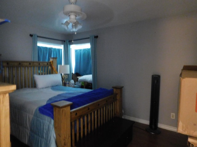 bedroom featuring a ceiling fan, baseboards, and wood finished floors