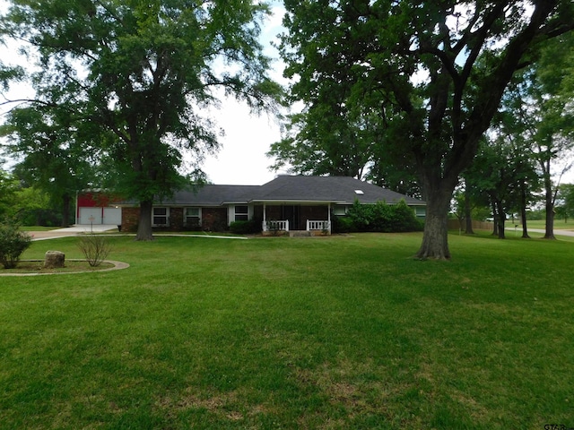 exterior space with concrete driveway, an attached garage, and a front lawn