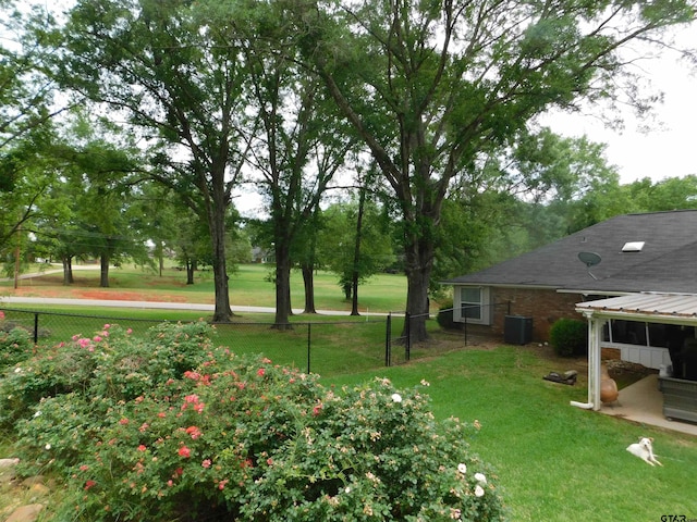 view of yard with fence and central AC unit
