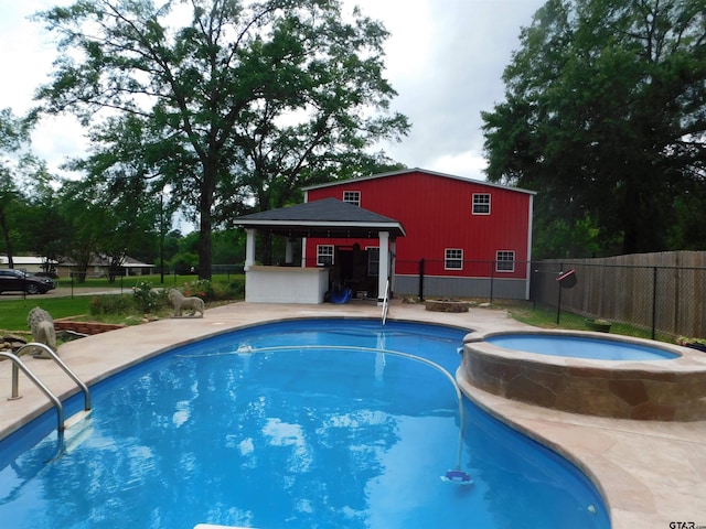 view of pool with a gazebo, fence, and a pool with connected hot tub