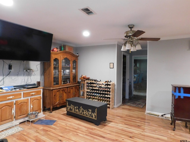 interior space with ceiling fan, visible vents, light wood-style floors, ornamental molding, and recessed lighting