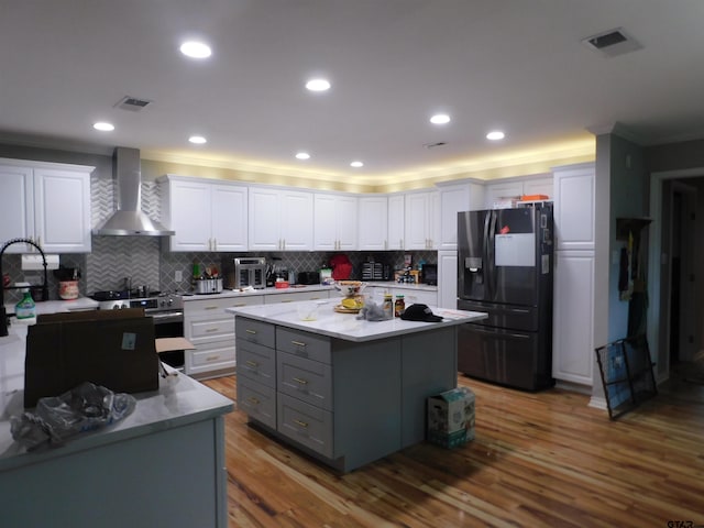 kitchen featuring visible vents, black refrigerator with ice dispenser, gray cabinets, wall chimney exhaust hood, and stainless steel electric range oven