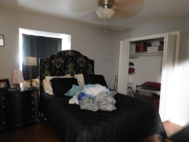 bedroom with a closet, a ceiling fan, and dark wood-style floors