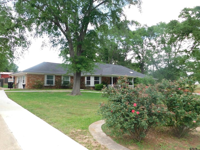 ranch-style home featuring brick siding and a front yard