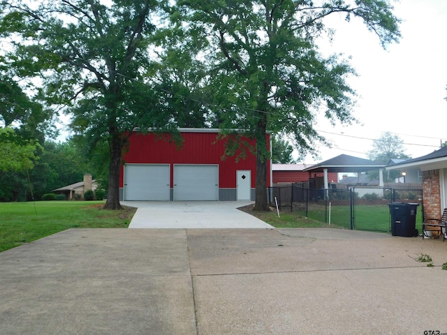detached garage with fence and concrete driveway