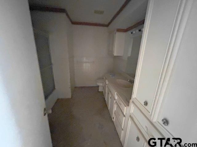 bathroom with crown molding, vanity, and toilet