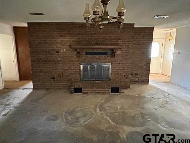 unfurnished living room featuring unfinished concrete flooring, a brick fireplace, a chandelier, and visible vents