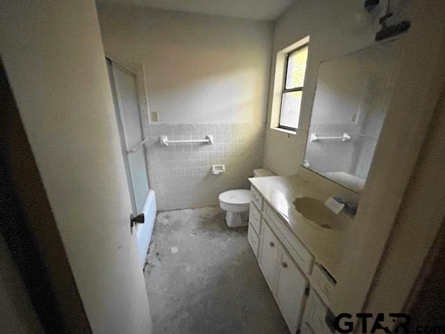 full bath with tile walls, wainscoting, vanity, and toilet