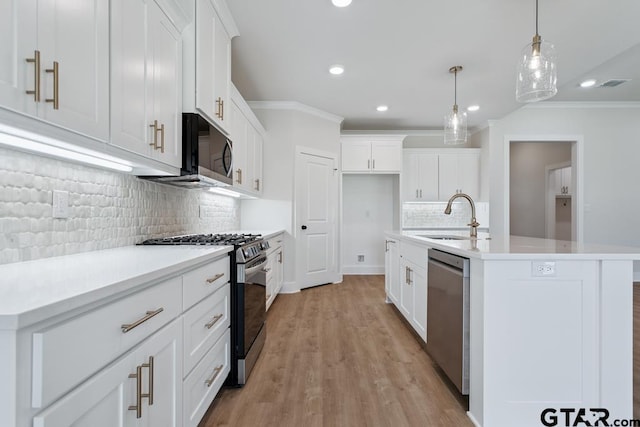 7130 Alexander Dr, Tyler, TX 75707 - kitchen featuring stainless steel appliances, ornamental molding, recessed lighting, tasteful backsplash, and light wood-style floors