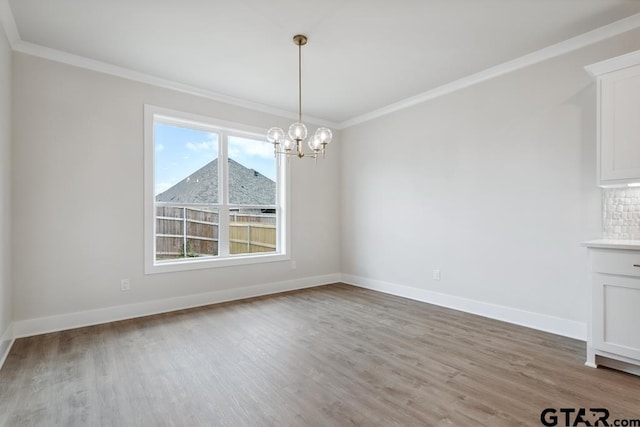 7130 Alexander Dr, Tyler, TX 75707 - unfurnished dining area featuring crown molding, a chandelier, and light wood-style floors