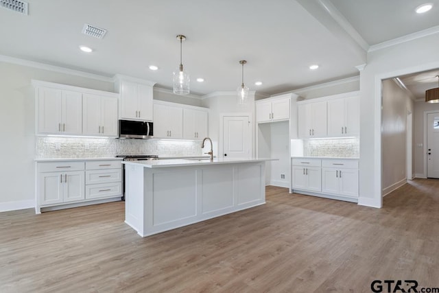 7130 Alexander Dr, Tyler, TX 75707 - kitchen featuring appliances with stainless steel finishes, backsplash, white cabinetry, light wood-style flooring, and light countertops