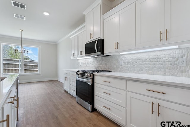 7130 Alexander Dr, Tyler, TX 75707 - kitchen featuring stainless steel gas range, crown molding, light countertops, tasteful backsplash, and white cabinetry