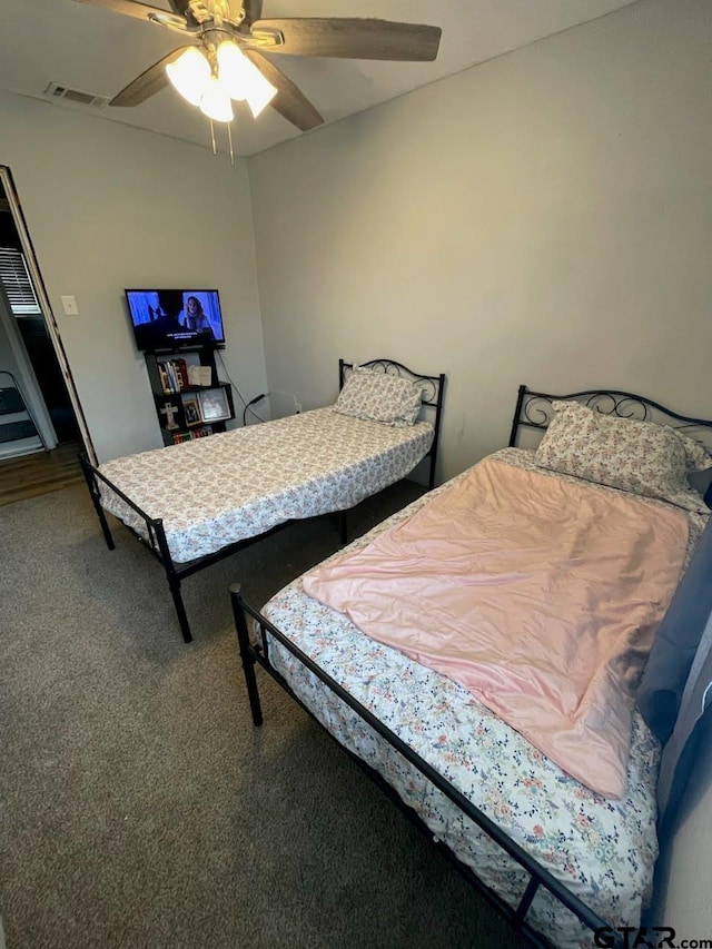 bedroom with visible vents, carpet flooring, and a ceiling fan