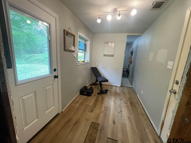 entryway with baseboards, light wood-style floors, and visible vents