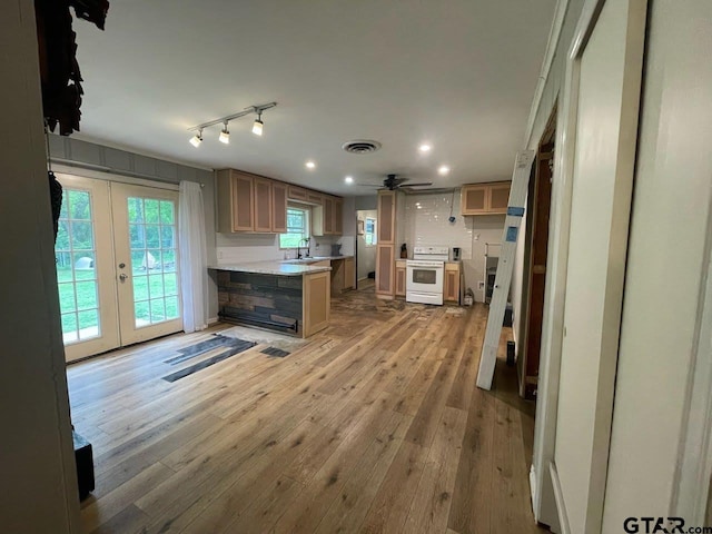 kitchen featuring french doors, a sink, white electric stove, visible vents, and a peninsula