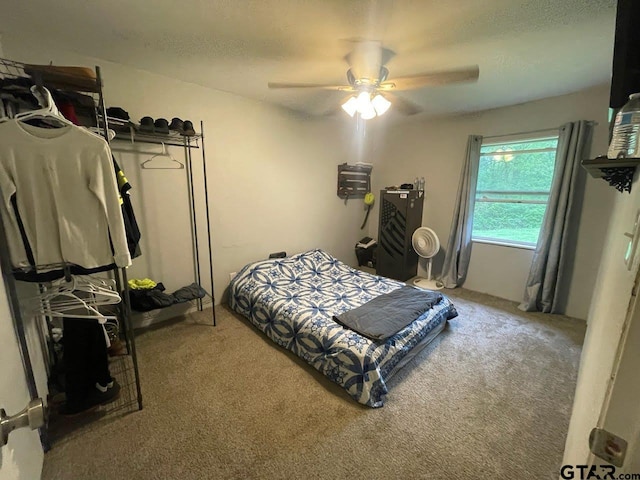 bedroom featuring light colored carpet, ceiling fan, and a textured ceiling