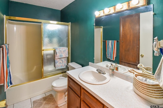 full bathroom featuring a textured ceiling, vanity, bath / shower combo with glass door, tile patterned floors, and toilet