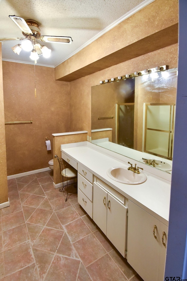 bathroom with ceiling fan, a textured ceiling, vanity, crown molding, and a shower with shower door