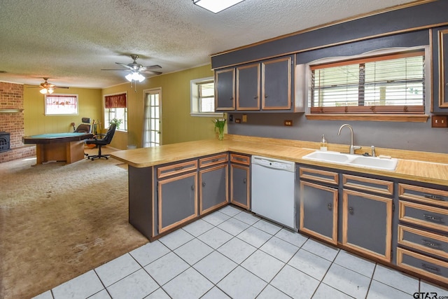 kitchen with light colored carpet, white dishwasher, kitchen peninsula, sink, and ceiling fan