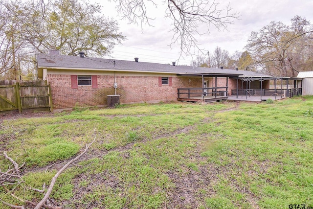 rear view of house featuring a wooden deck and a yard