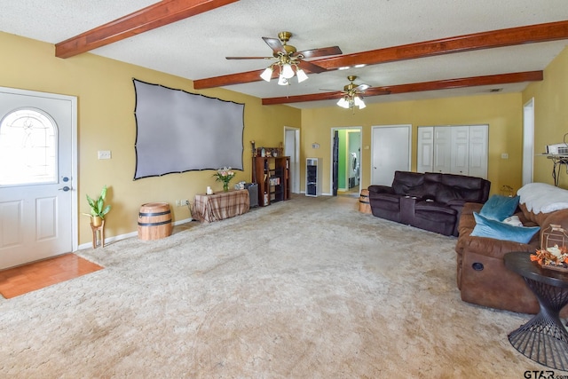 carpeted living room featuring beamed ceiling, ceiling fan, and a textured ceiling