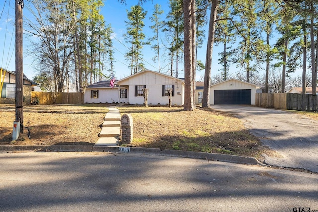 view of front of house featuring a garage, an outdoor structure, and fence