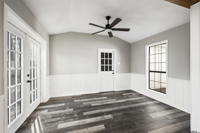 entrance foyer featuring a wealth of natural light, french doors, a wainscoted wall, and vaulted ceiling