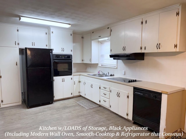 kitchen with under cabinet range hood, light countertops, black appliances, white cabinetry, and a sink