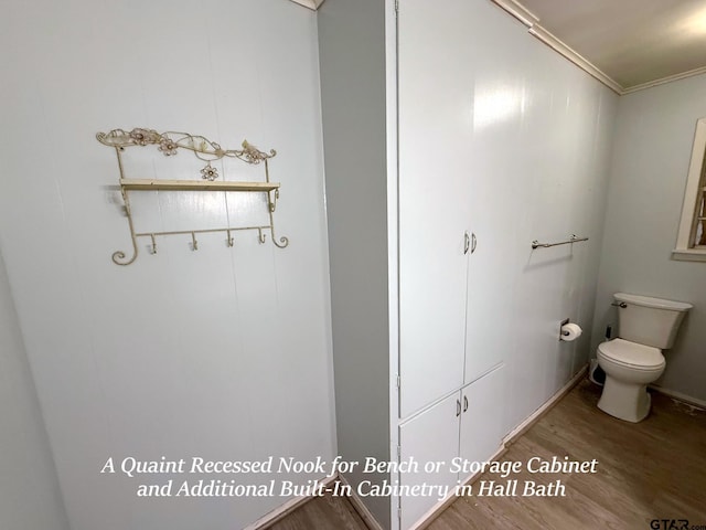 bathroom featuring ornamental molding, toilet, and wood finished floors