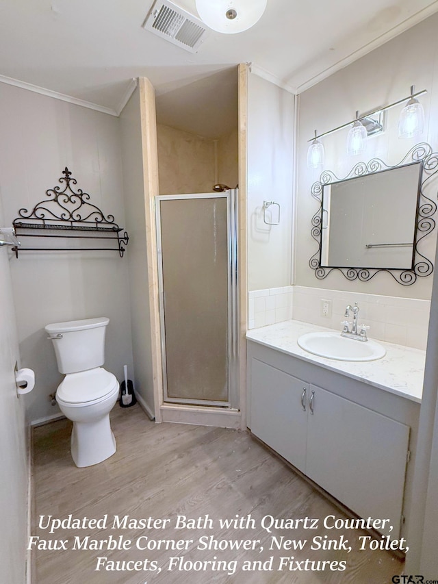 bathroom with ornamental molding, a stall shower, visible vents, and wood finished floors