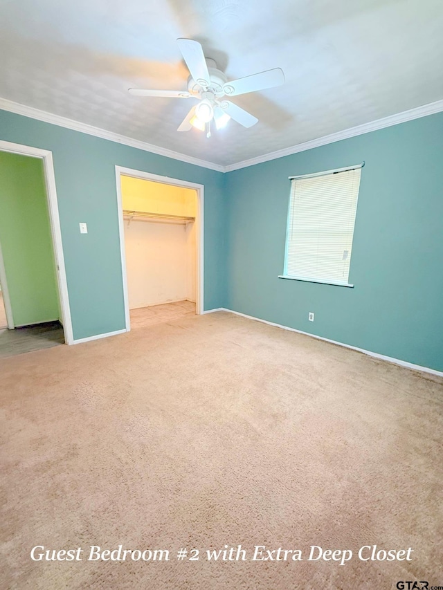 unfurnished bedroom with ornamental molding, a walk in closet, and light colored carpet