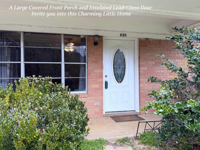 property entrance featuring brick siding