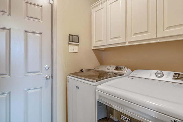 laundry room with separate washer and dryer and cabinets